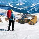 Escursionista con i ramponcini su un sentiero innevato