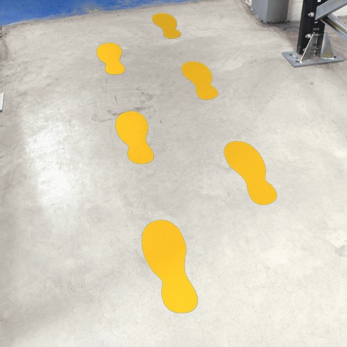 Yellow footprints marking the pedestrian walkway in a warehouse