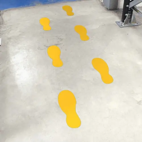 Impronte gialle che segnano il percorso pedonale in magazzino