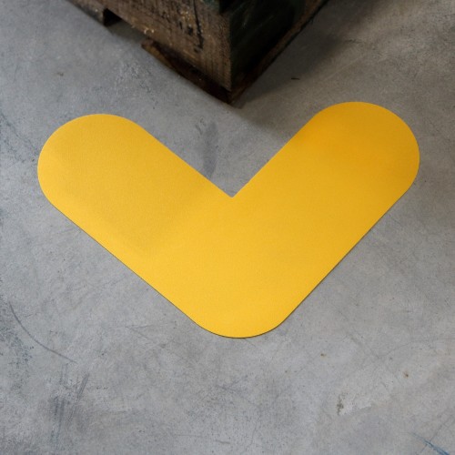 Angolo adesivo giallo 20x20 cm posato sul pavimento del magazzino